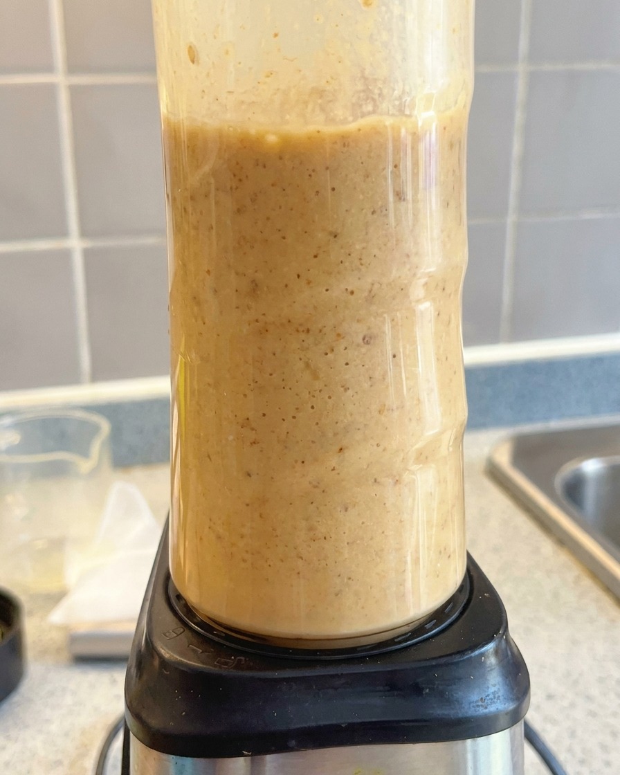 Un frullatore che trasforma la base della zuppa in un liquido cremoso di colore marrone chiaro.