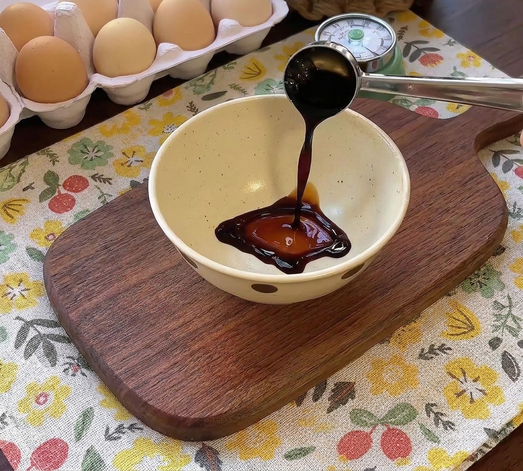 Salsa scura versata in una ciotolina insieme ad altri condimenti per la marinatura dellhamburger.