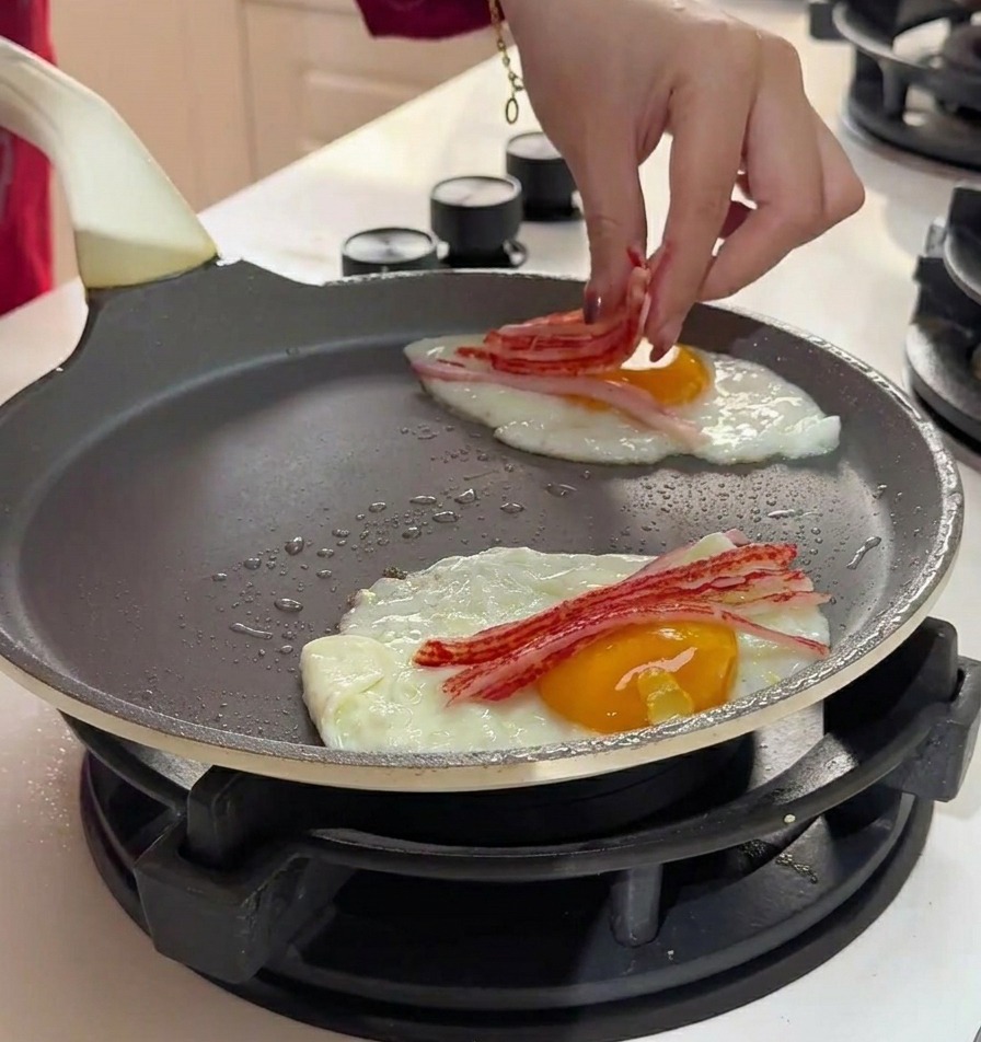 Mano che posiziona sottili strisce di surimi sopra le uova in cottura.