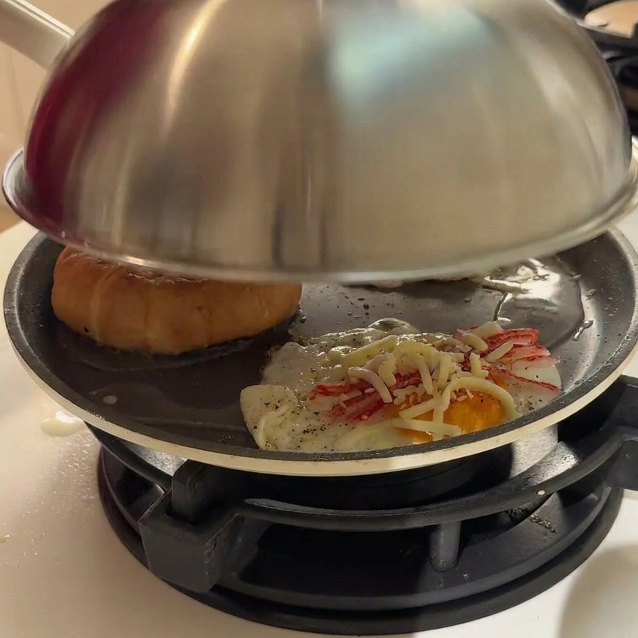 Vapore che esce dai bordi di un coperchio metallico sopra una padella.