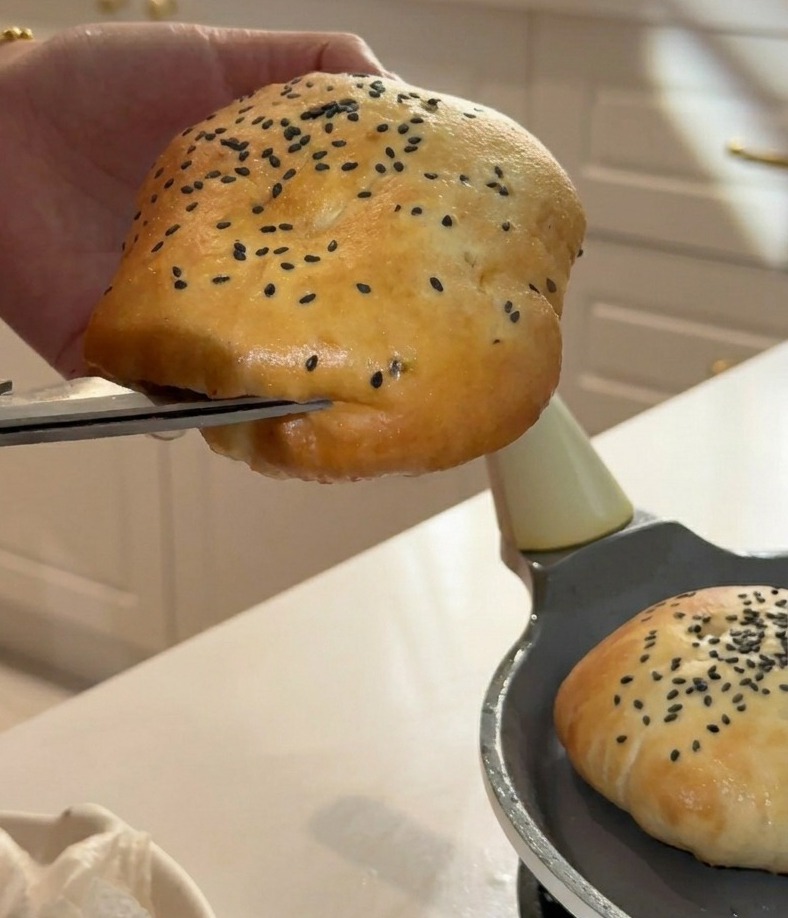 Uso di forbici da cucina per tagliare il lato di un panino soffice per creare una tasca per il ripieno.