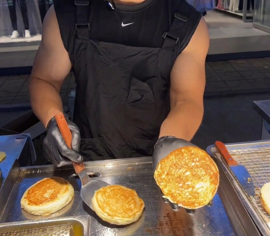 Una persona solleva metà panino per mostrare la superficie dorata e croccante.