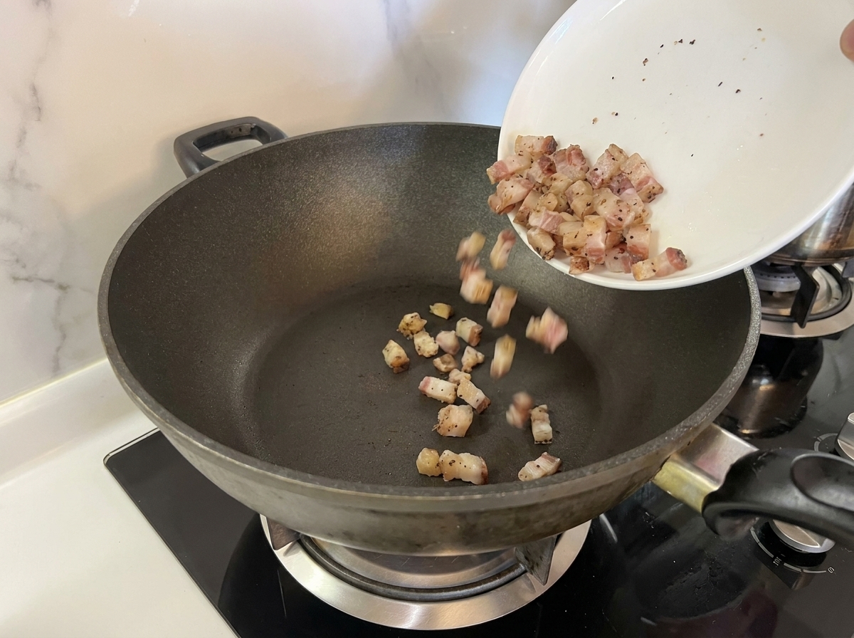 Cubetti di guanciale messi in una padella fredda.
