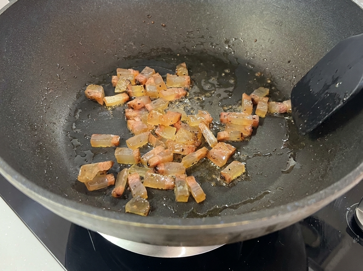 Guanciale che rosola nel suo stesso grasso in padella.