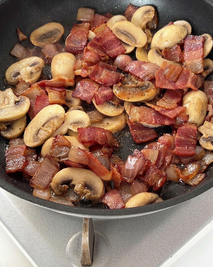 Padella con pancetta, cipolle e funghi spolverati con pepe nero.