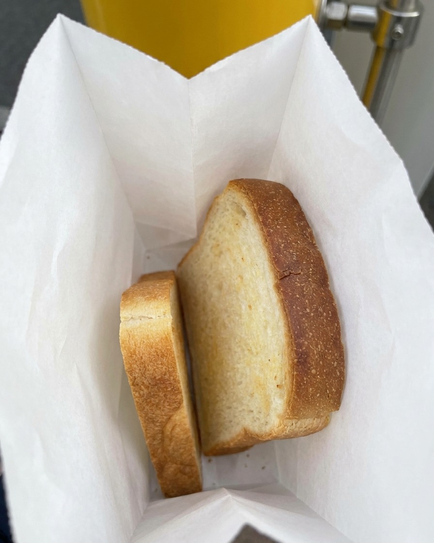 Due fette spesse di pane bianco da sandwich allinterno di un sacchetto di carta.