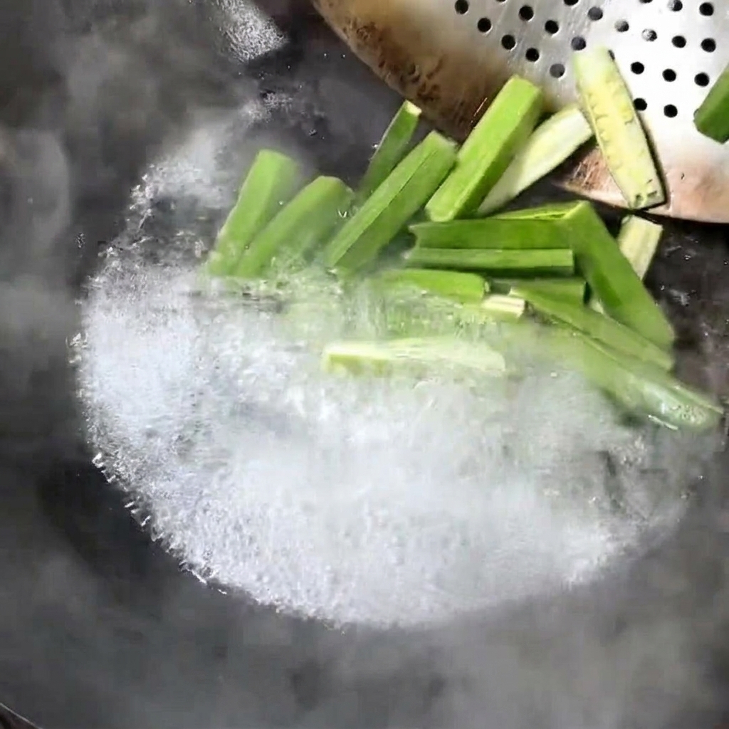 Pezzi di okra fresca che bollono in un wok.