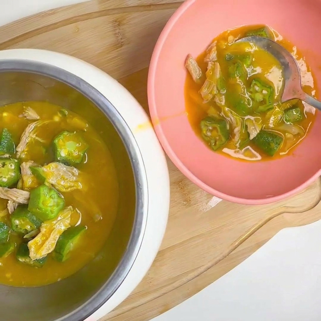 Baccelli di okra verde fresca lavati sotto un getto delicato di acqua corrente.