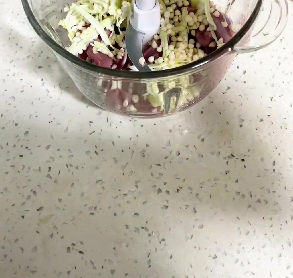 Carne di anatra e semi di okra frullati allinterno di un robot da cucina.