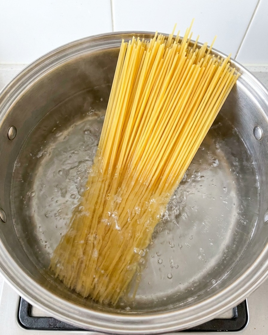 Spaghetti in cottura in una grande pentola di acqua bollente.
