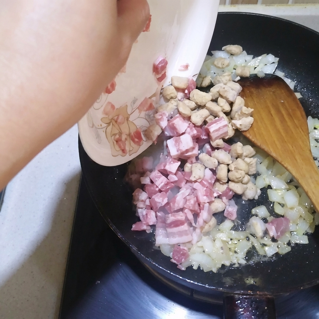 Cubetti di pancetta e manzo saltati in padella con cipolla e aglio.