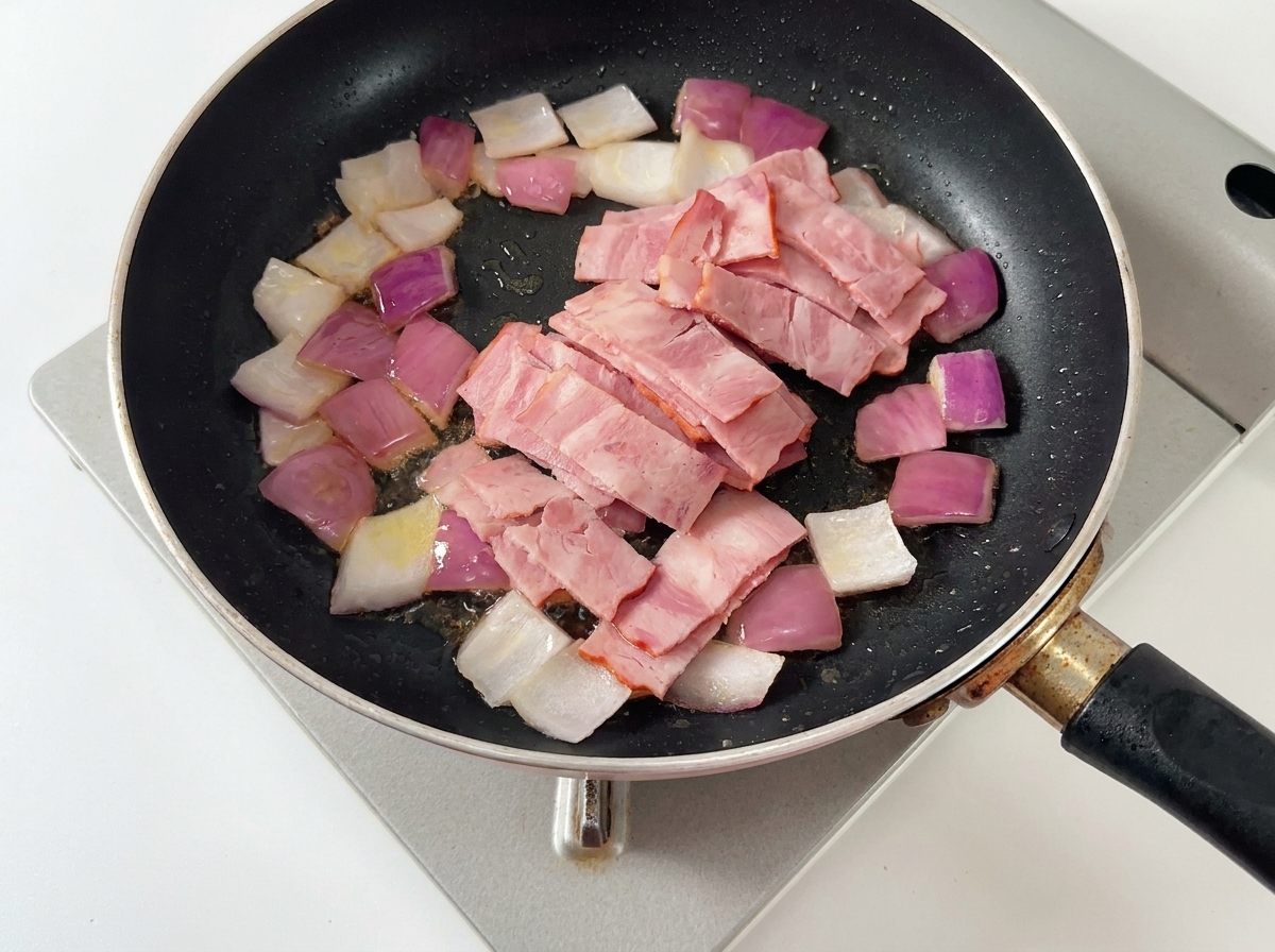 Pancetta e funghi che cuociono in padella.