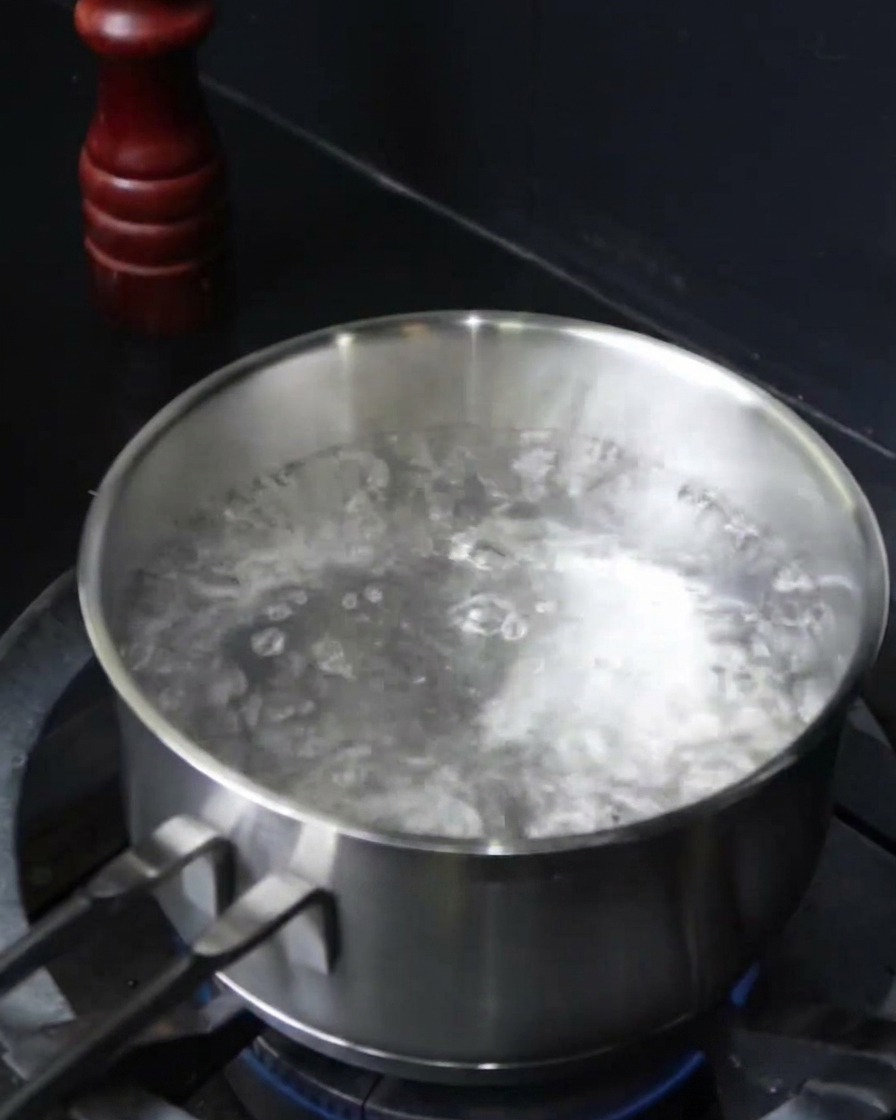 Spaghetti immersi in una pentola di acqua bollente salata.
