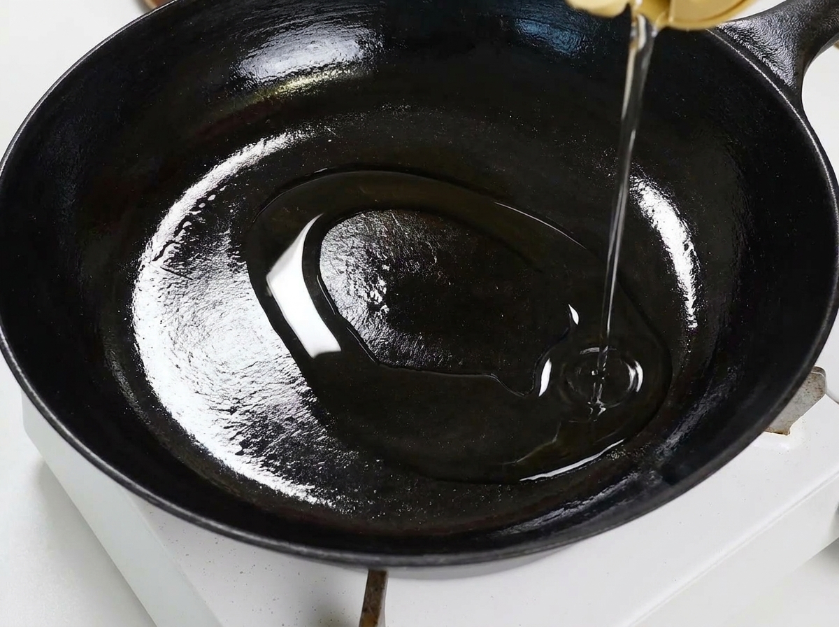 Aglio e peperoncino che sfrigolano nellolio in una padella piatta.