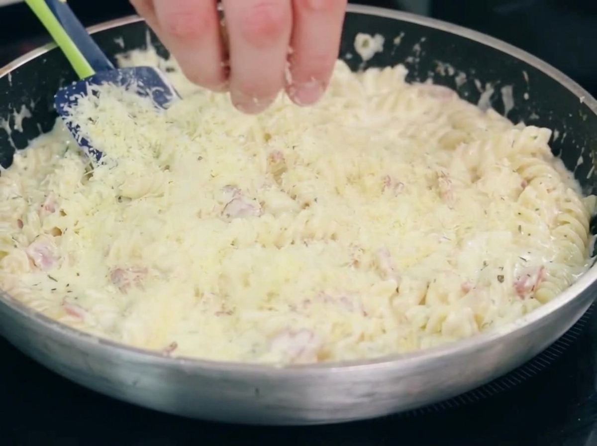 Cipolla e aglio che cuociono in padella insieme alla pancetta.