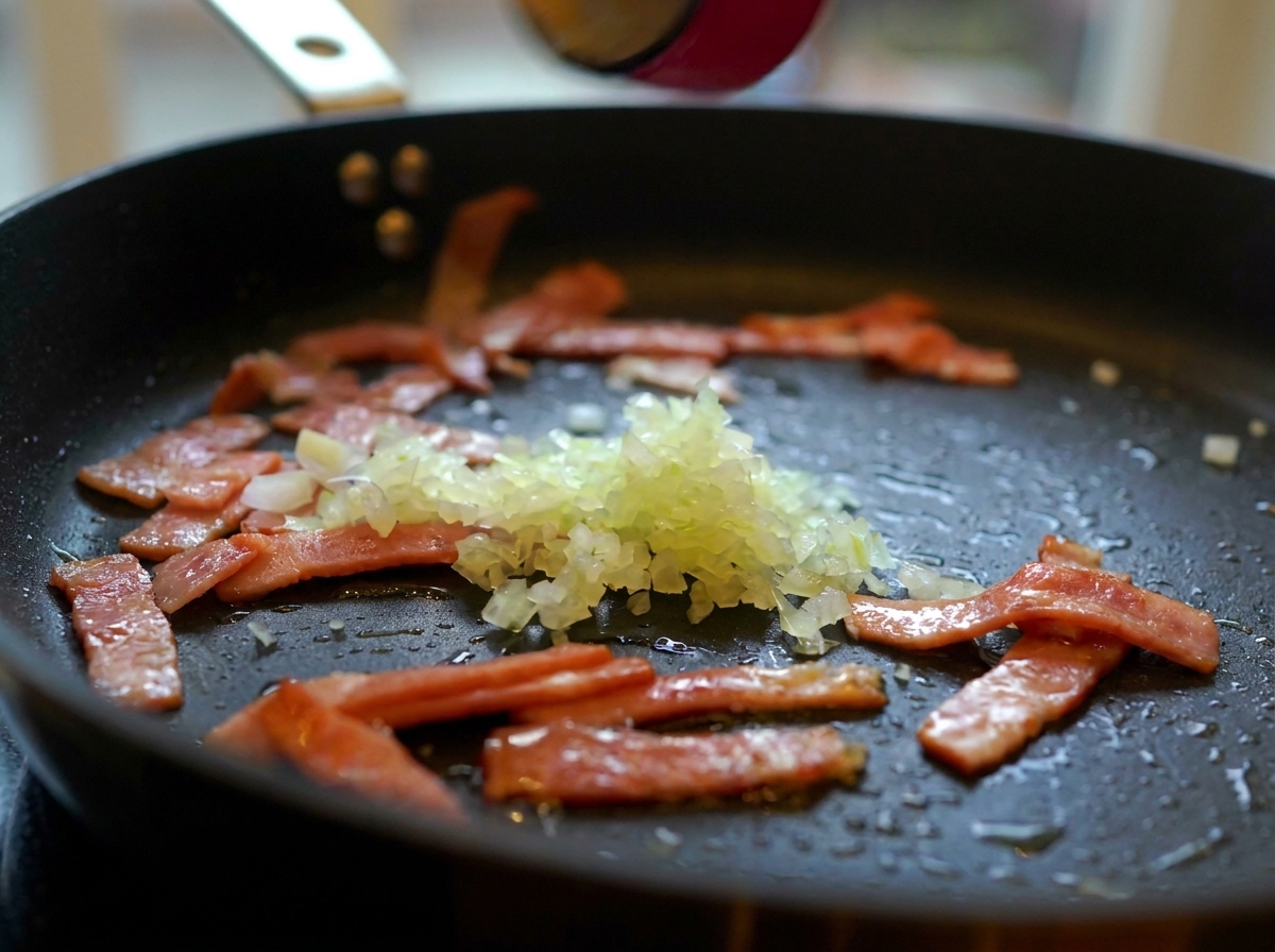 Cipolla tritata, aglio e funghi affettati aggiunti alla padella con la pancetta.