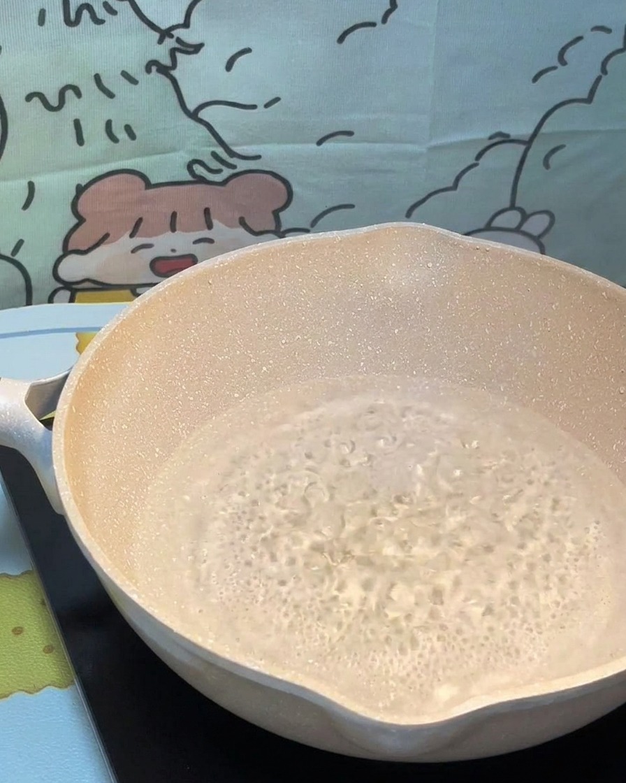 Pasta secca immersa in una pentola di acqua bollente.
