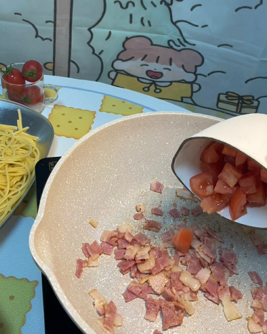 Pomodori freschi tritati aggiunti in padella con la pancetta croccante.