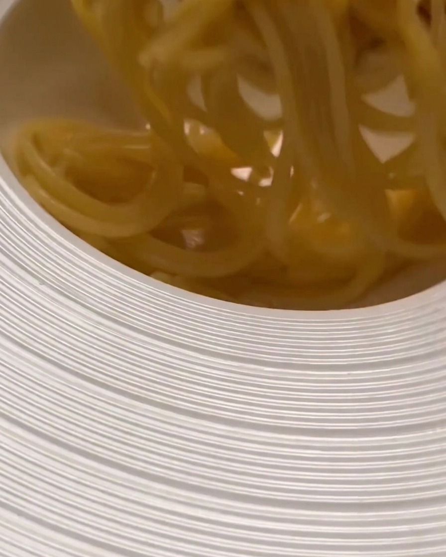 Pasta cotta trasferita in una ciotola ampia, pronta per essere mescolata al sugo.
