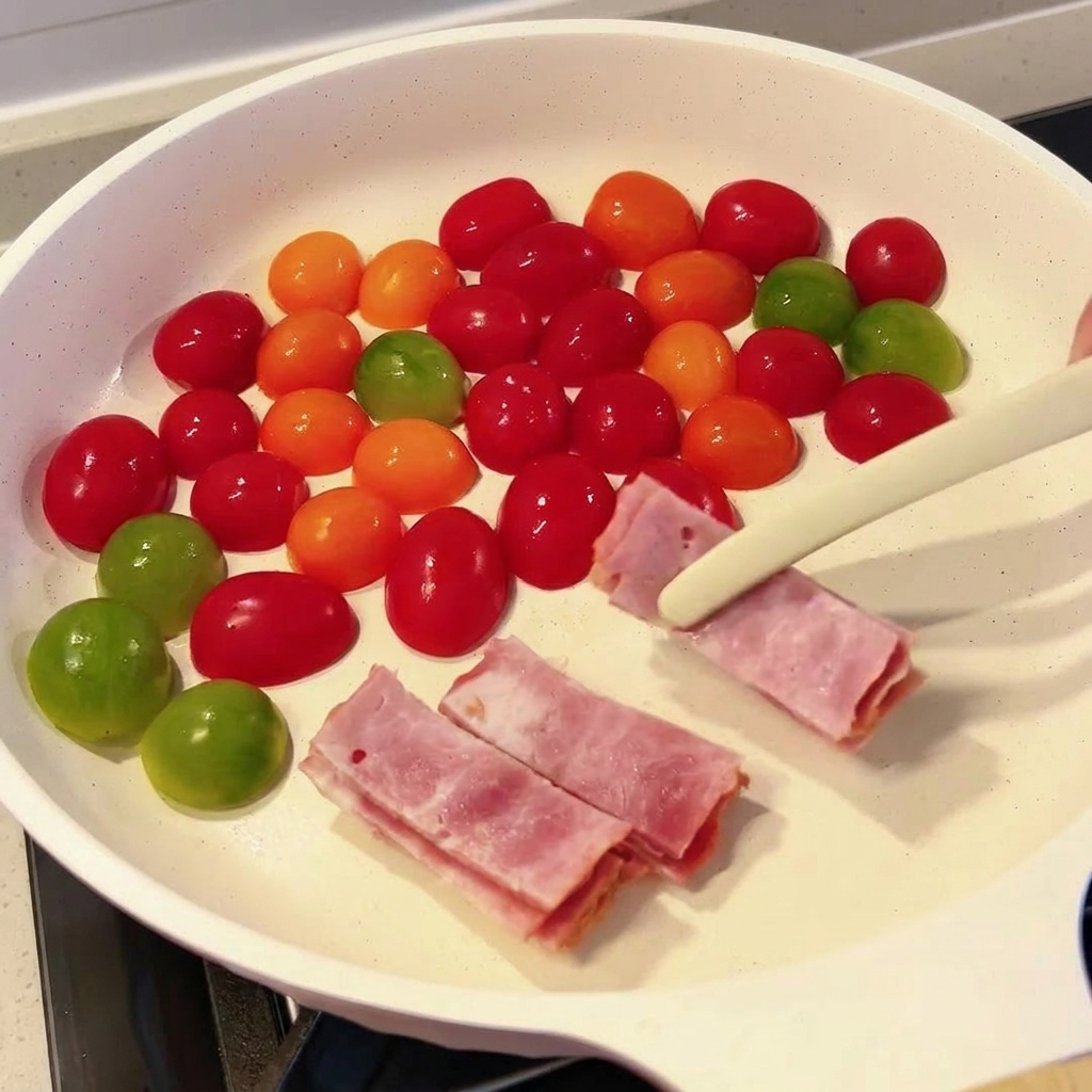 Fette di pancetta cruda messe in padella con i pomodorini.