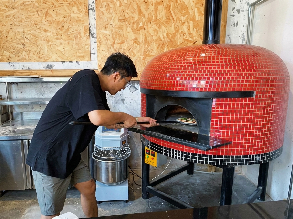 Pizza infornata in un forno a legna caldissimo usando una pala dacciaio.