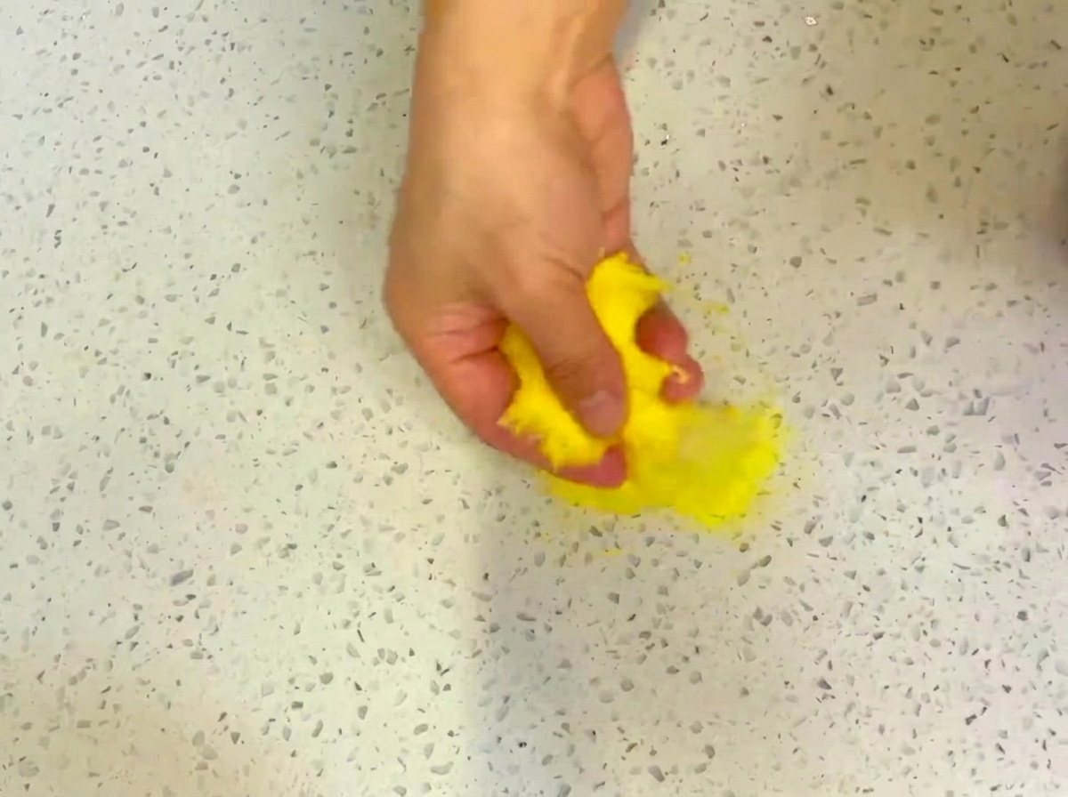 Impasto per pizza steso su una superficie infarinata con farina di mais.