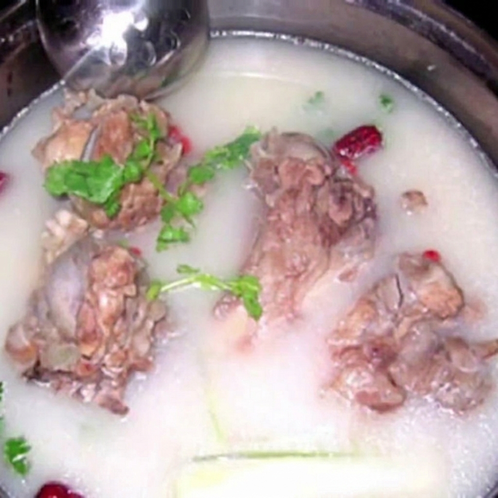 Ossa di maiale immerse in un brodo lattiginoso e denso.