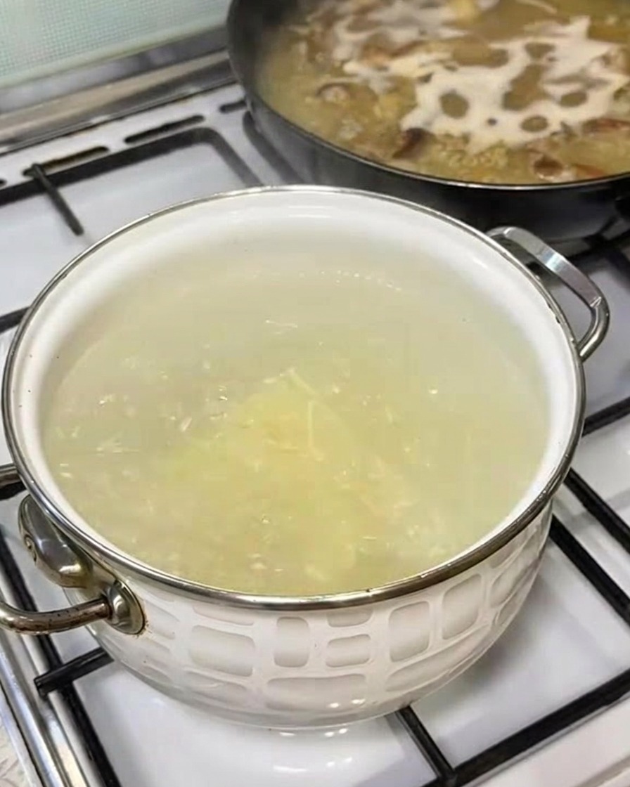 Un fascio di noodles ramen freschi immersi in una pentola di acqua bollente.