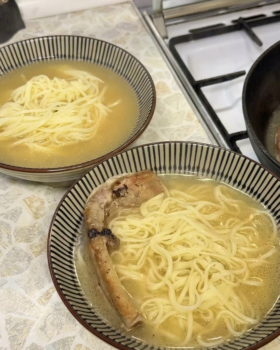 Primo piano di una costina di maiale tenera e dorata posizionata in una ciotola di ramen.
