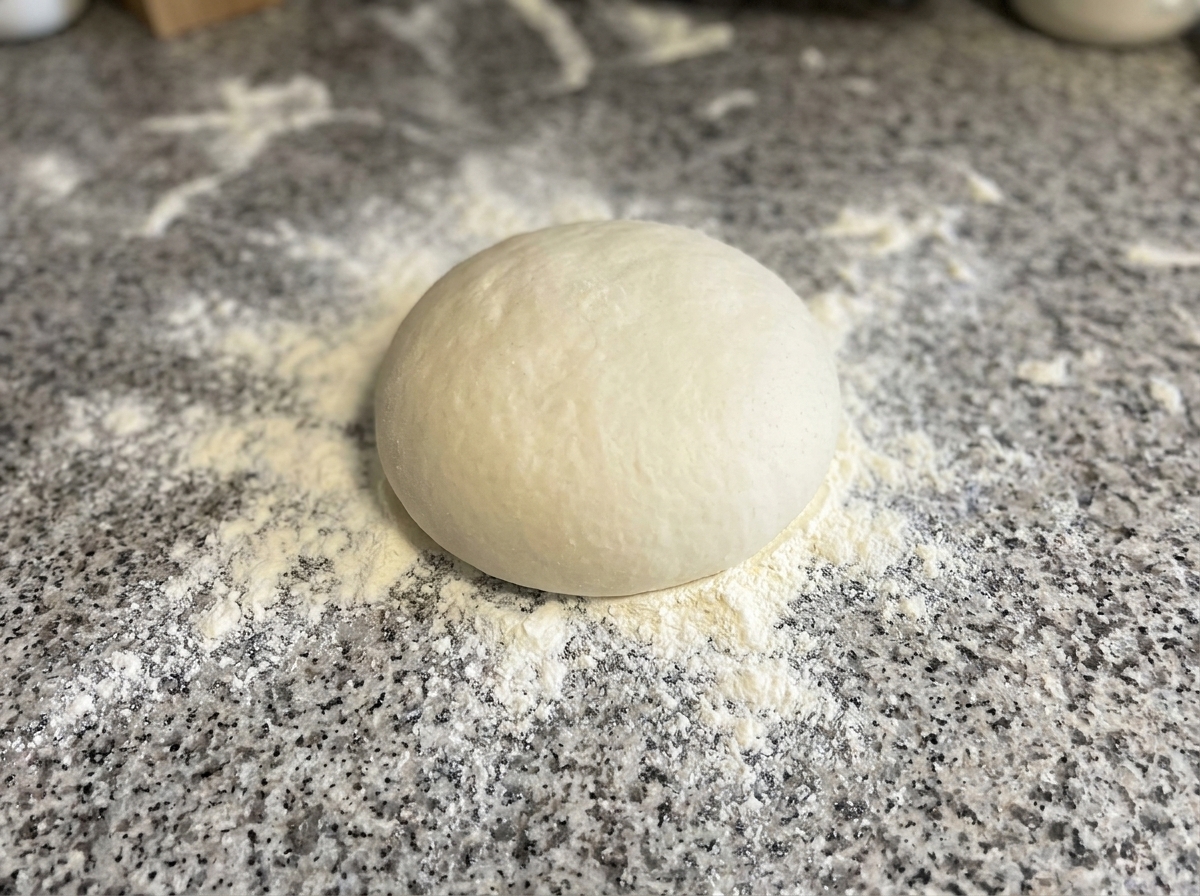 Impasto pressato e modellato in cerchio su una superficie infarinata.
