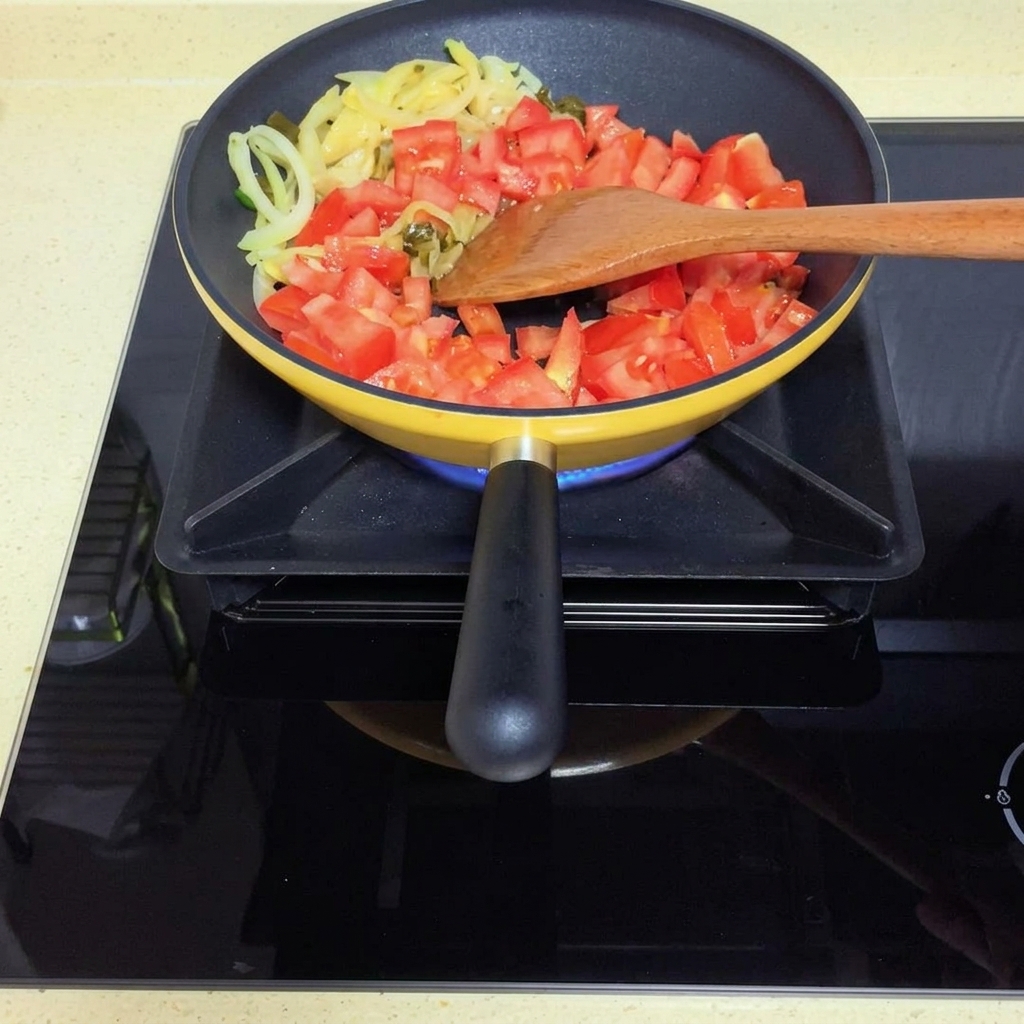 I pomodori si ammorbidiscono in padella formando una salsa.