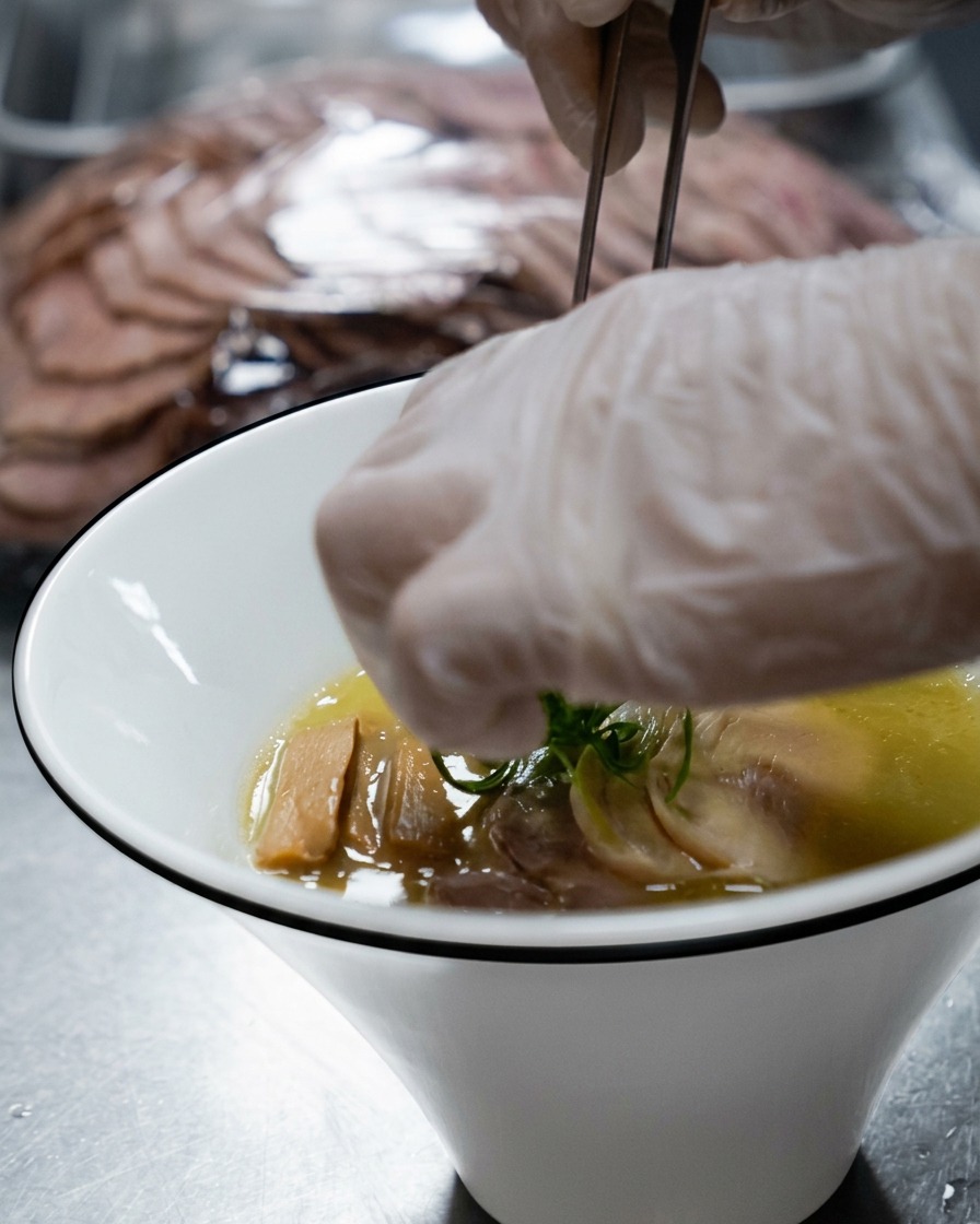 Cipollotti freschi tritati cosparsi come guarnizione finale sopra la ciotola di ramen.
