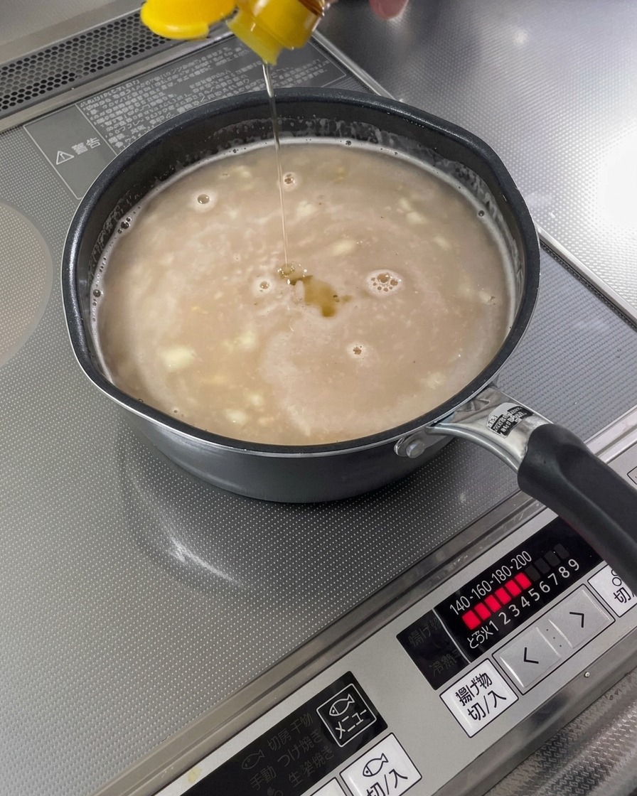 Olio di sesamo versato in una base di zuppa finita.