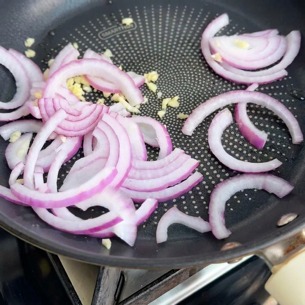 Cipolla e aglio che soffriggono in padella.