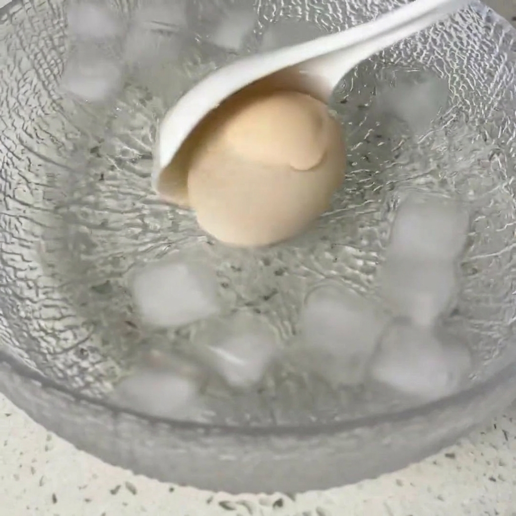 Luovo cotto immerso in una ciotola con acqua e ghiaccio.