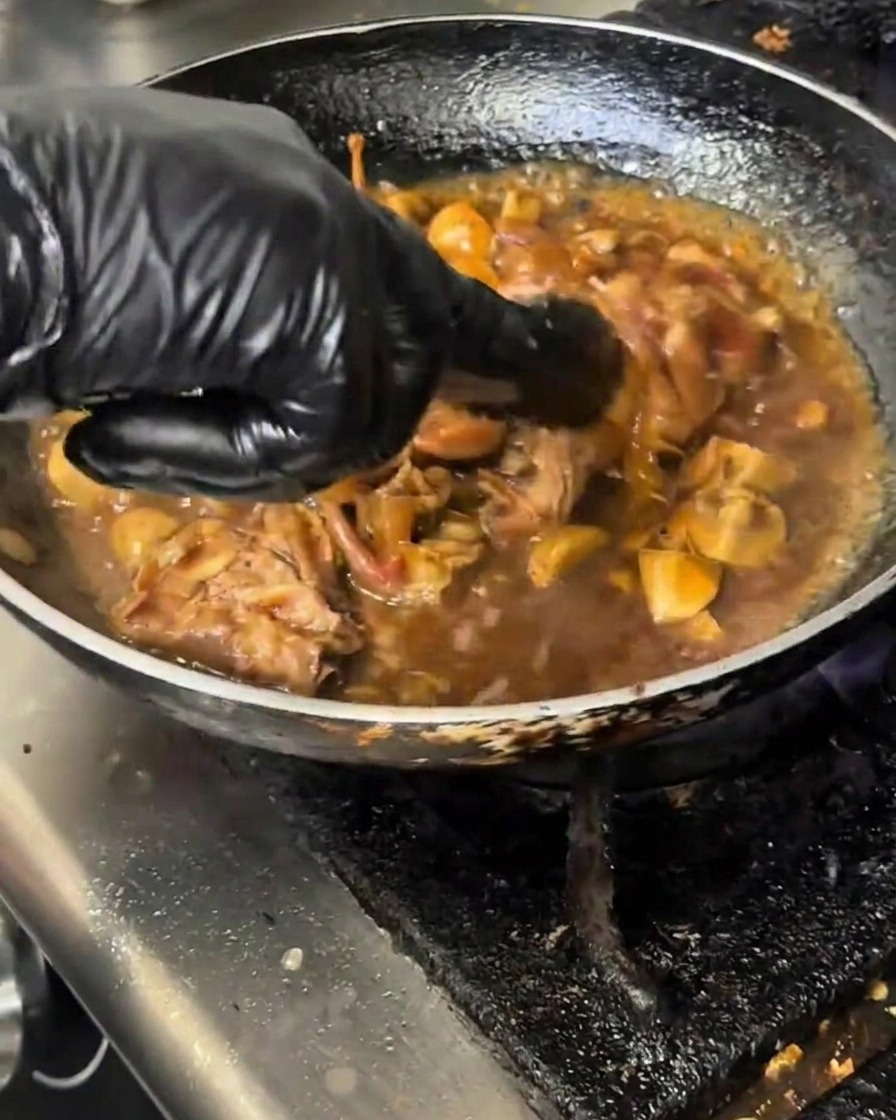 Versamento di un composto di amido in una padella di manzo e funghi che sobbolle.