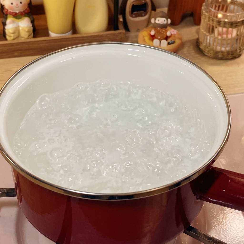 Involtini di manzo surgelati immersi in acqua bollente in una pentola rossa.