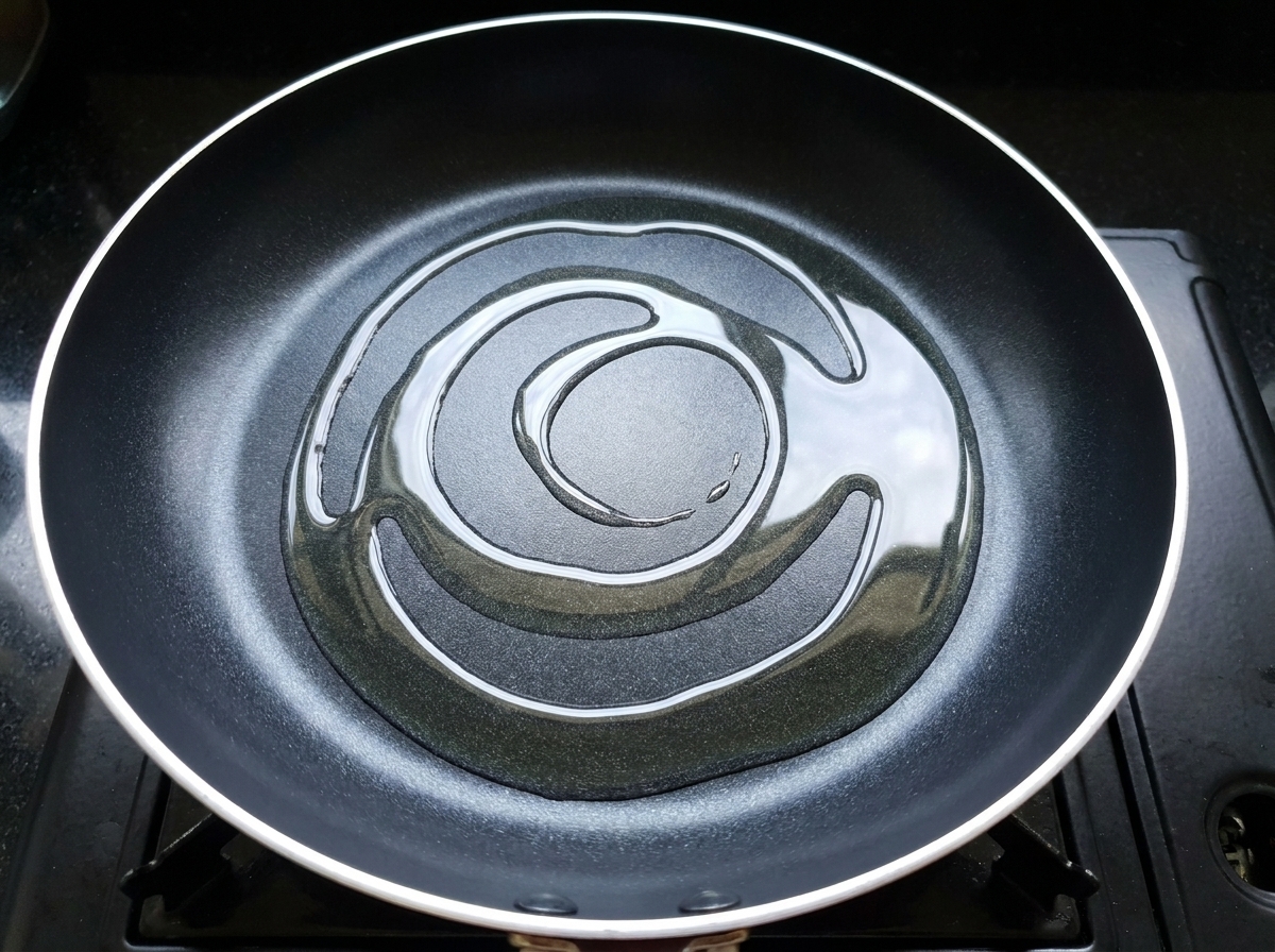 Pezzi di pollo marinati aggiunti in una padella calda e oleosa.