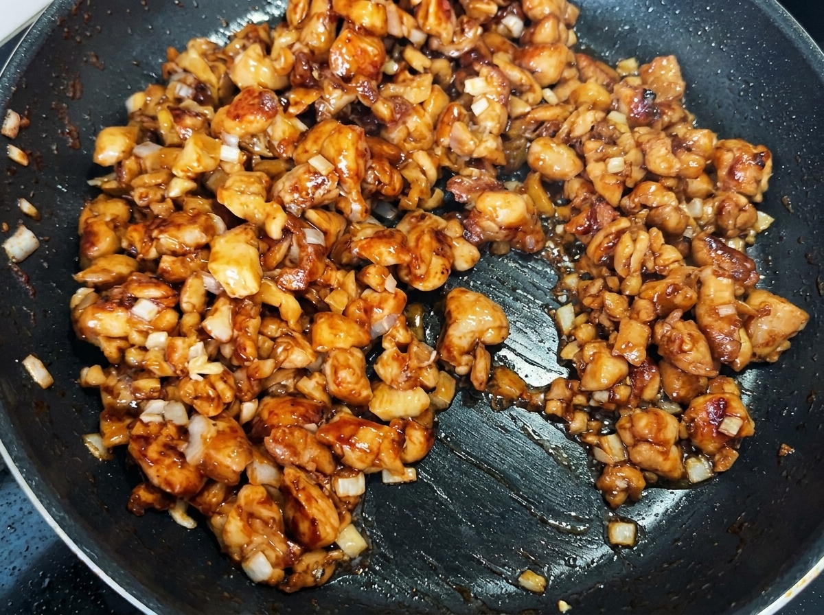 Senape in salamoia tritata mescolata con il pollo e i cipollotti nella padella.