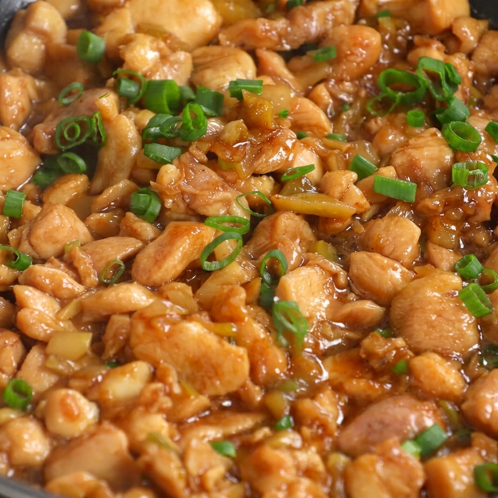 Stir-fry di pollo e senape finito guarnito con cipollotti freschi in padella.