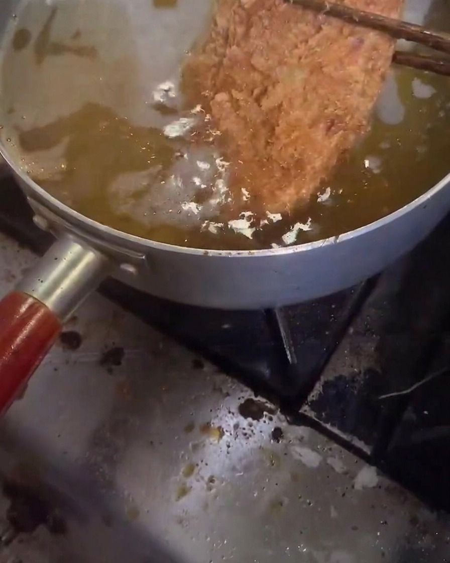 Una cotoletta di maiale fritta per la seconda volta in olio molto caldo e spumeggiante.