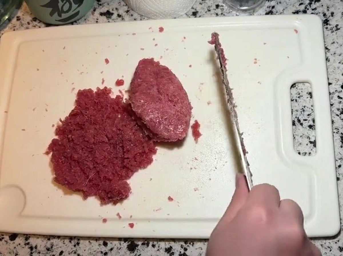 Un coltello che taglia e ripiega la pasta di tonno e maionese insieme al resto del tonno tritato.