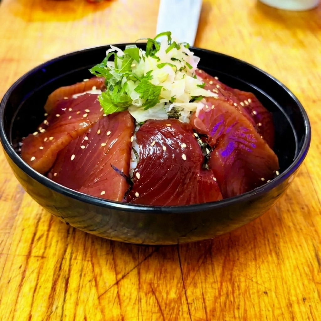Una ciotola di riso Zuke Don finita con tonno marinato, zenzero, shiso e una leggera spolverata di semi di sesamo bianco.