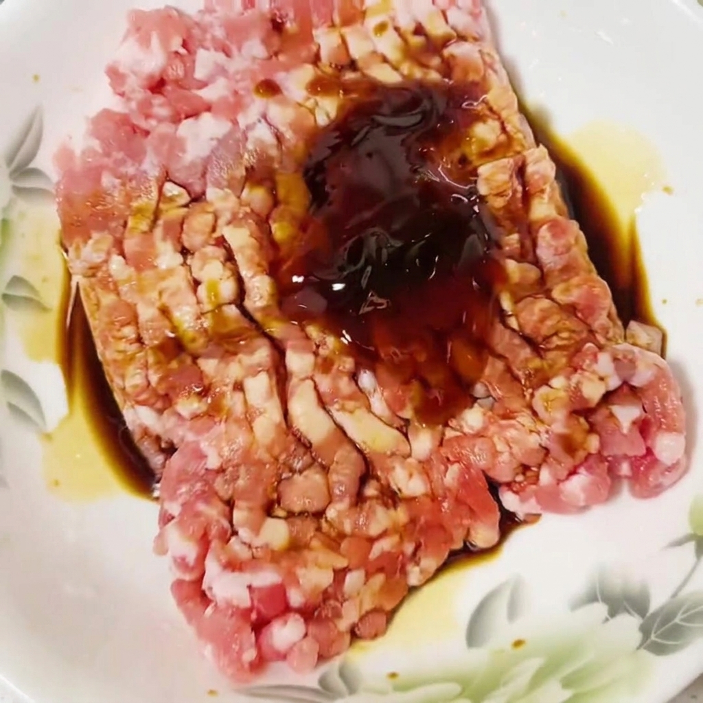 Essenza di pollo cosparsa sopra il composto di carne cruda.