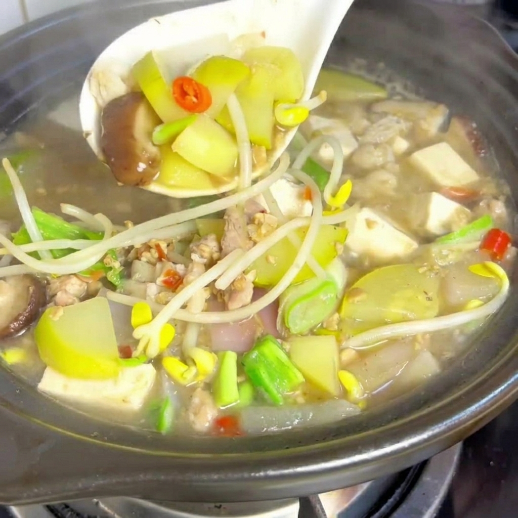 Cubetti di tofu morbido posizionati nella pentola dello stufato in ebollizione.