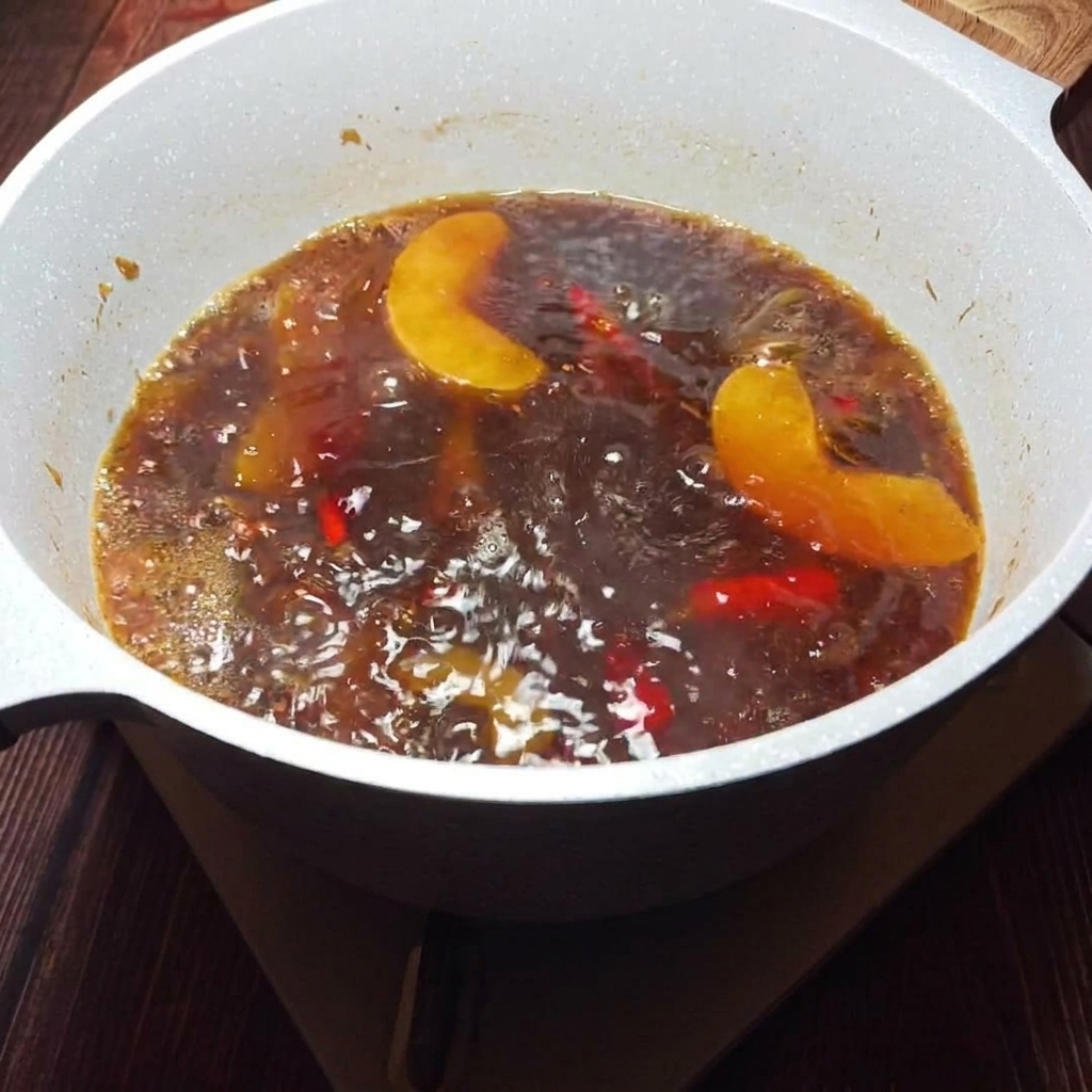 Un brodo dorato e aromatico filtrato attraverso un colino per rimuovere i solidi.