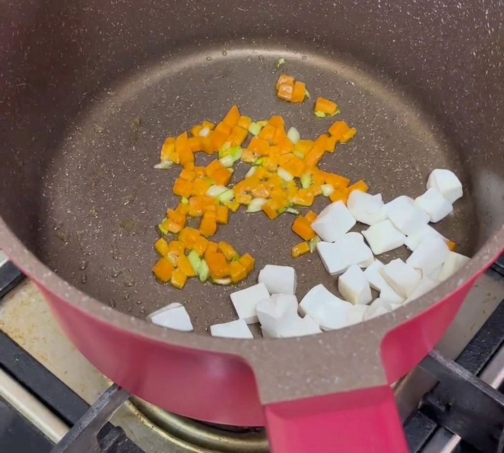 Cubetti di tofu, manzo macinato cotto e carote saltate combinati insieme in padella.