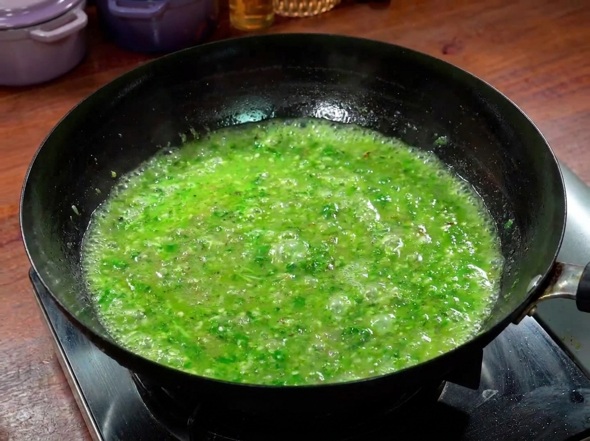 Strisce di manzo che cuociono in un brodo verde piccante nel wok.