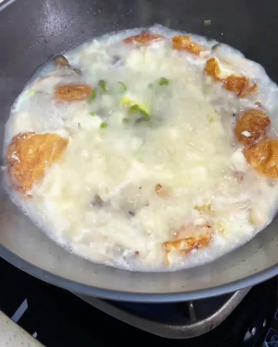 La zuppa di funghi e tofu completata, guarnita con una manciata di cipollotti freschi tritati.