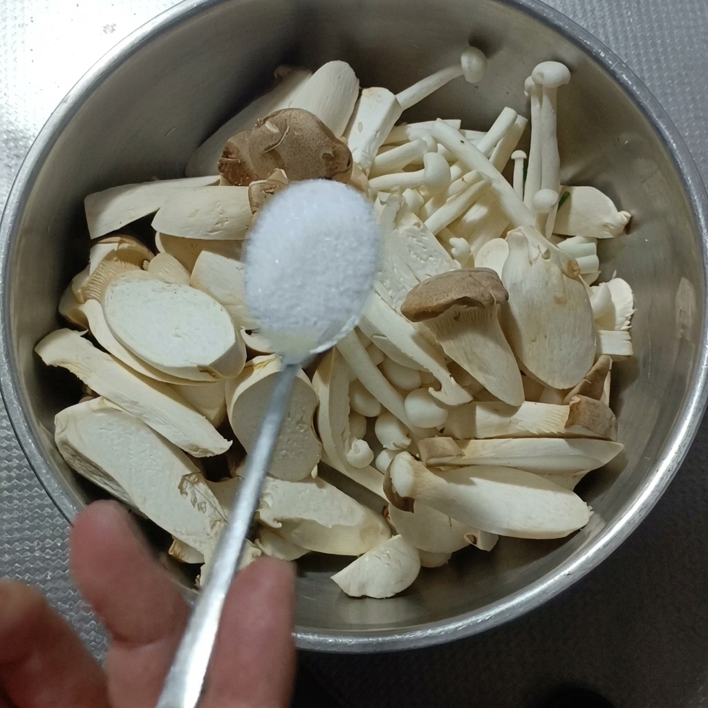 Funghi orecchione e pioppini in una ciotola di metallo con sale.